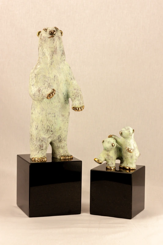 Isbjørnen står her sammen med skulpturen med isbjørne unger på granit.